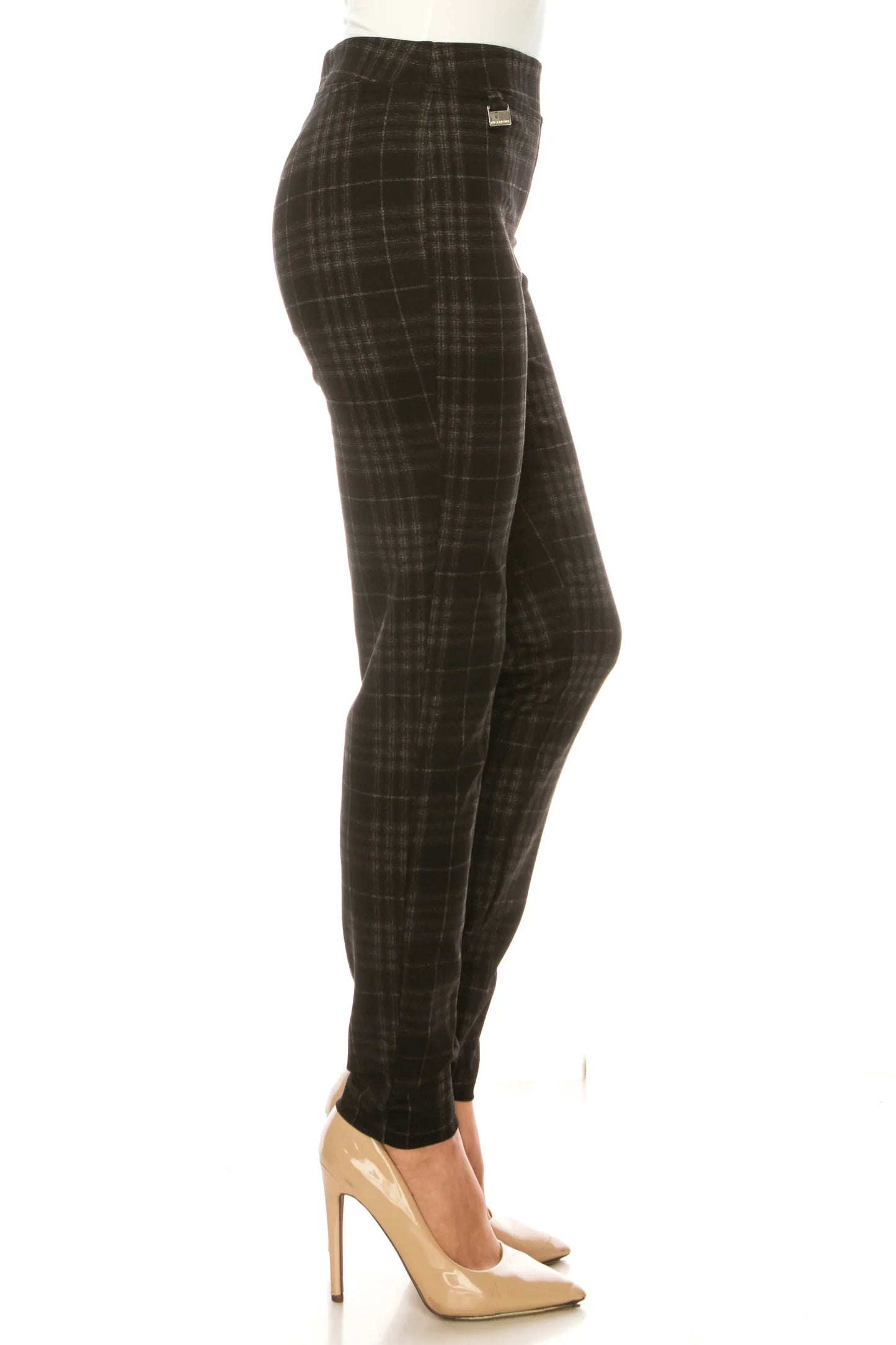 Woman wearing charcoal grey plaid slim-fit trousers and nude pointed-toe pumps.