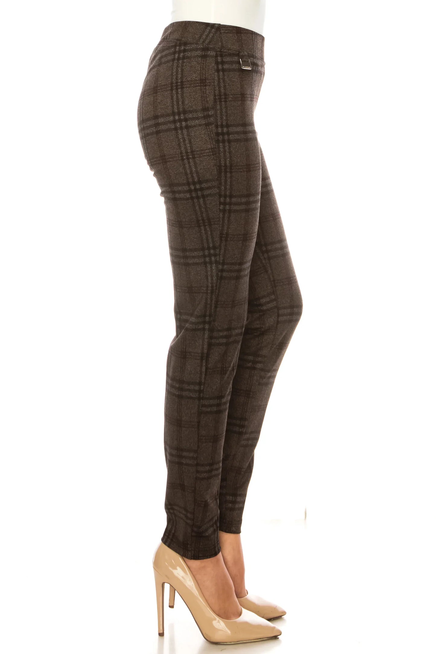 Woman wearing brown plaid slim-fit trousers and nude pointed-toe heels.