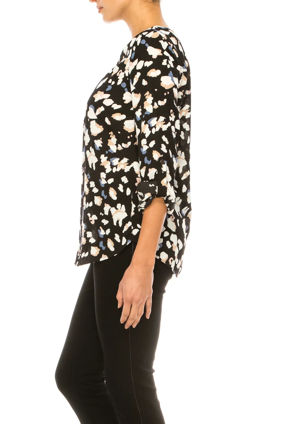 Woman wearing a black abstract floral print blouse and black trousers.