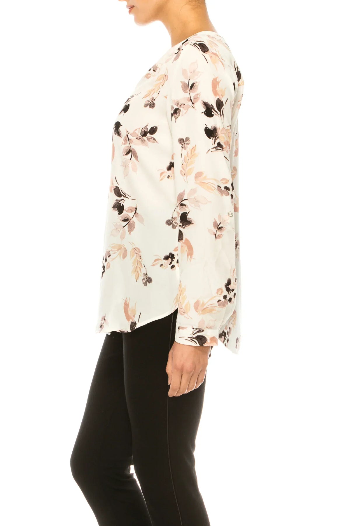 Woman wearing a white long-sleeve floral print blouse and black trousers.
