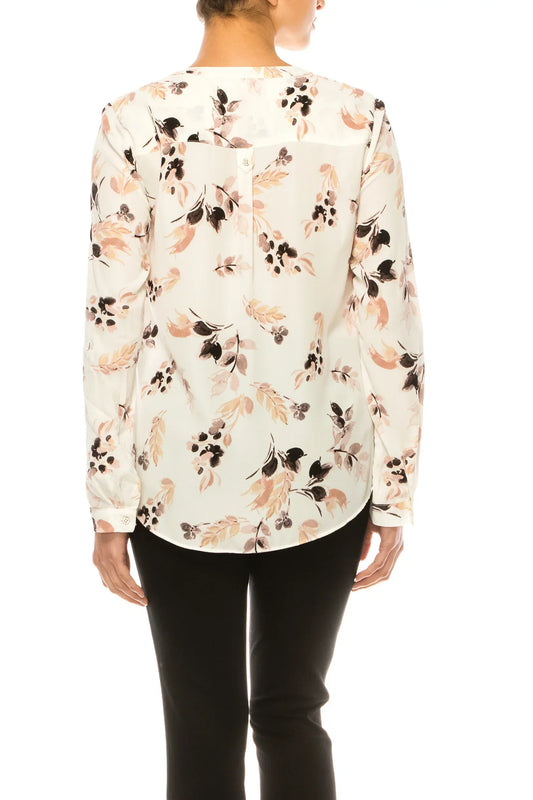Back view of a woman wearing a white long-sleeve blouse with a brown and black floral print.