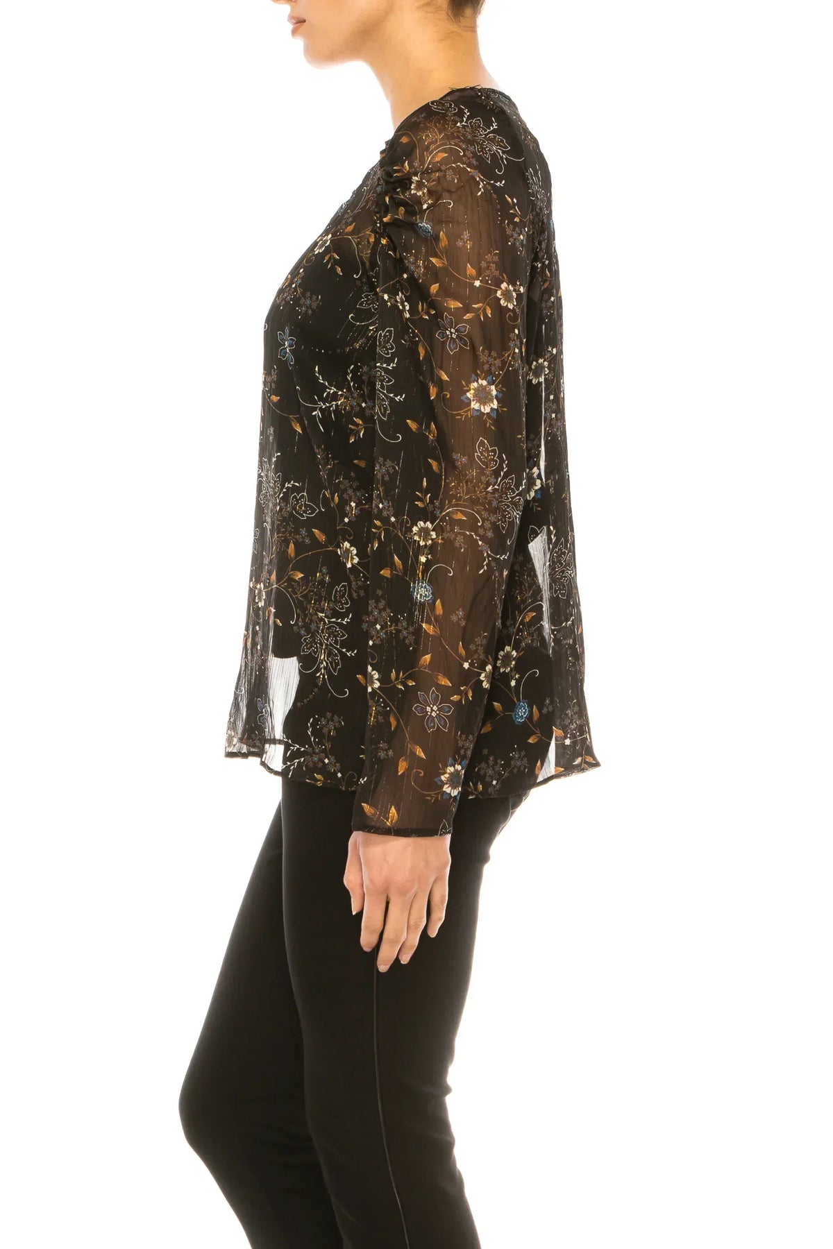 Woman wearing a black sheer long-sleeve blouse with gold floral embroidery and black pants.