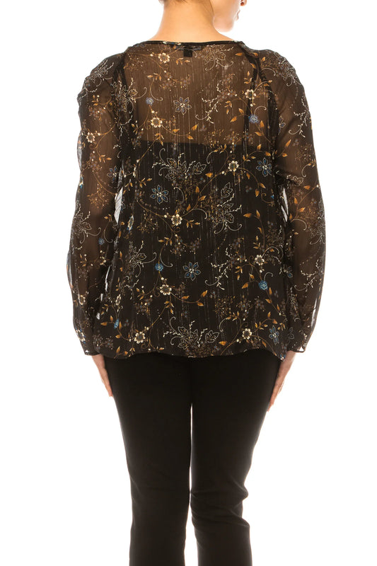 Back view of a woman wearing a sheer black floral print blouse and black pants.