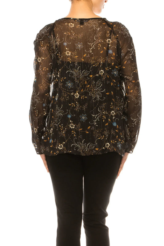 Back view of a woman wearing a sheer black floral print blouse and black pants.